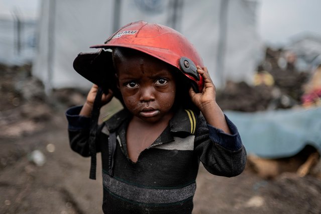 A child displaced by the fighting between M23 rebels and government soldiers holds a damaged helmet at the camp in Goma, Democratic Republic of the Congo, Tuesday, February 11, 2025. (Photo by Moses Sawasawa/AP Photo)