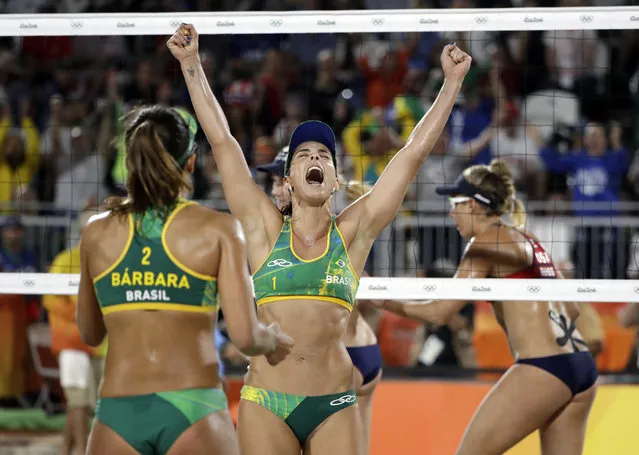 Brazil's Agatha Bednarczuk, center, celebrates a point against the United States with teammate Barbara Seixas de Freitas during a women's beach volleyball semifinal match at the 2016 Summer Olympics in Rio de Janeiro, Brazil, Wednesday, August 17, 2016. (Photo by Marcio Jose Sanchez/AP Photo)