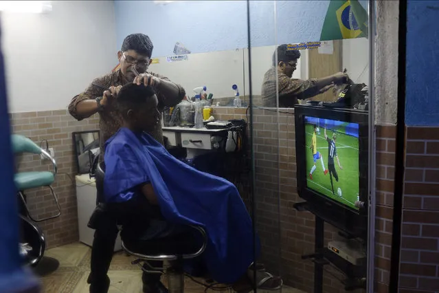 The barber Adauto gives a sharp razor line like that of the soccer star Gabriel Jesus to Bernardo in the favela Vidigal during the start of the men's gold medal soccer match between Brazil and Germany as part of Rio 2016 on Saturday, August 20, 2016. (Photo by Aaron Ontiveroz/The Denver Post)