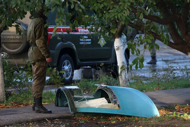 The fragment of a Sukhoi Su-34 military jet is seen at the crash site in the courtyard of a residential area in the town of Yeysk in southwestern Russia on October 18, 2022. At least 13 people, including three children, were killed after a Russian military plane crashed into a residential area of Yeysk, a town in southwest Russia near the border with Ukraine, Moscow authorities said Tuesday as search operations ended. (Photo by AFP Photo/Stringer)