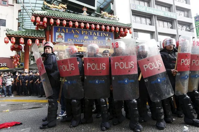 Riot police protect the entrance to Chinatown from  “Red Shirt” demonstrators during a rally to celebrate Malaysia Day and to counter a massive protest held over two days last month that called for Prime Minister Najib Razak's resignation over a graft scandal, in Malaysia's capital city of Kuala Lumpur September 16, 2015. (Photo by Olivia Harris/Reuters)