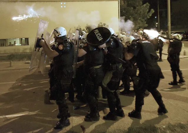 Montenegro police officers fire tear gas during protest in Podgorica, Montenegro, Wednesday, June 24, 2020. Seven police officers were injured and dozens protesters have been detained, including two lawmakers of the Democratic Front, in opposition riots that broke out in several Montenegrin cities on Wednesday. (Photo by Risto Bozovic/AP Photo)