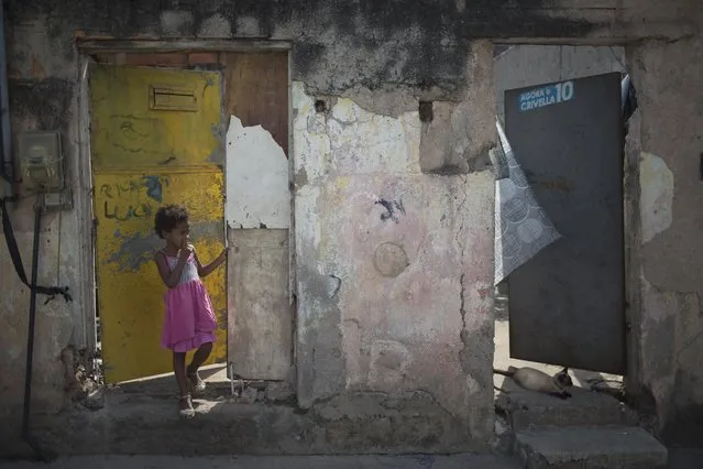 A kid stands at entrance of his house located in the same street where Brazilian judo gold medalist Rafaela Silva used to live at Cidade de Deus slum in Rio de Janeiro, Brazil, Tuesday, August 9, 2016. Cidade de Deus is the former home of Silva who grew up there. If not for the sport that helped her climb up and out, “I could still be living in City of God now”, she said through tears after winning on Monday. (Photo by Leo Correa/AP Photo)