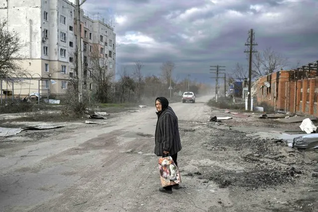 An old woman walks in the Kherson region village of Arkhanhelske on November 3, 2022, which was formerly occupied by Russian forces. (Photo by Bulent Kilic/AFP Photo)