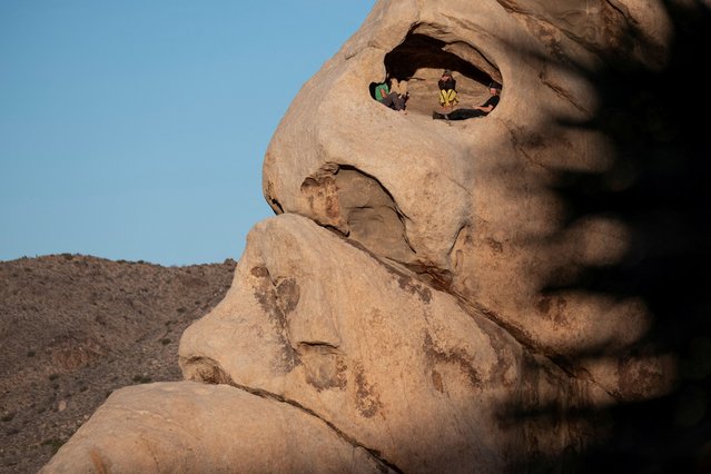 People sit inside a rock dwelling at Hidden Valley Campground in Joshua Tree National Park, in California, on March 19, 2025. (Photo by Joel Angel Juarez/Reuters)