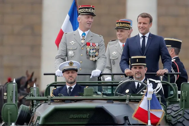 France's President Emmanuel Macron (R) and French Armies Chief Staff General Francois Lecointre (L) stand in the command car as they review troops before the start of the Bastille Day military parade on the Place de la Concorde in Paris, France, 14 July 2020. Bastille Day, the French National Day, is held annually on 14 July to commemorate the storming of the Bastille fortress in 1789. This year Germany, Austria, Switzerland and Luxembourg, which took in French COVID-19 patients, are special guests of honor. (Photo by Christophe Ena/EPA/EFE)