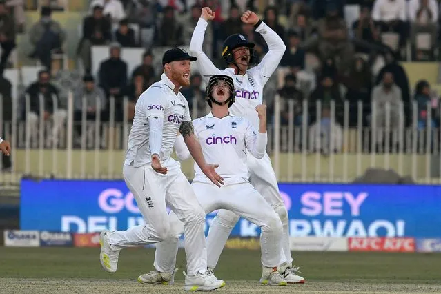 England's captain Ben Stokes (L) celebrates with teammate after last wicket out of Pakistan's Naseem Shah (not pictured) durign the fifth and final day of the first cricket Test match between Pakistan and England at the Rawalpindi Cricket Stadium, in Rawalpindi on December 5, 2022. (Photo by Aamir Qureshi/AFP Photo)