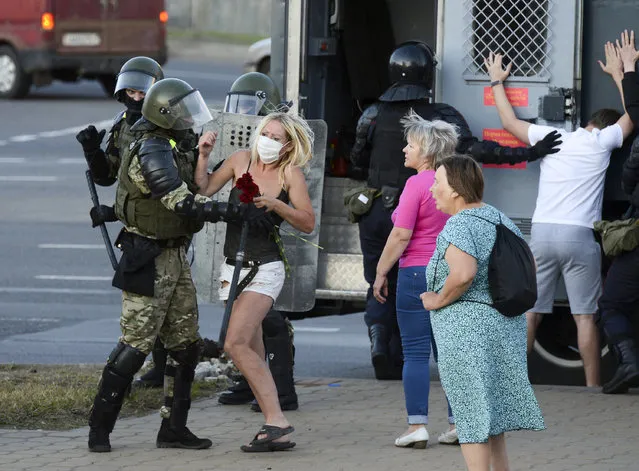 A woman fights with a police officer as the other police officers detain an opposition supporter protesting the election results as protesters encounter aggressive police tactics in the capital of Minsk, Belarus, Tuesday, August 11, 2020. Heavy police cordons blocking Minsk's central squares and avenues didn't discourage the demonstrators who again took to the streets chanting “Shame!” and “Long live Belarus!” Police moved quickly Tuesday to separate and disperse scattered groups of protesters in the capital, but new pockets of resistance kept mushrooming across downtown Minsk. (Photo by AP Photo/Stringer)