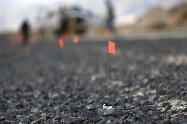 Orange flags mark small pieces of wreckage along a railroad track from the crash of Virgin Galactic's SpaceShipTwo near Cantil, California, on November 2, 2014. (Photo by David McNew/Reuters)