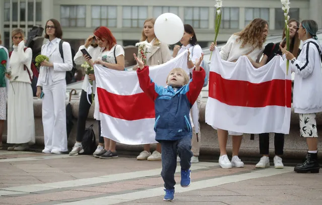 A young boy catches a balloon during a protest in Minsk, Belarus, Sunday, August 23, 2020. Demonstrators are taking to the streets of the Belarusian capital and other cities, keeping up their push for the resignation of the nation's authoritarian leader. President Alexander Lukashenko has extended his 26-year rule in a vote the opposition saw as rigged. (Photo by Dmitri Lovetsky/AP Photo)