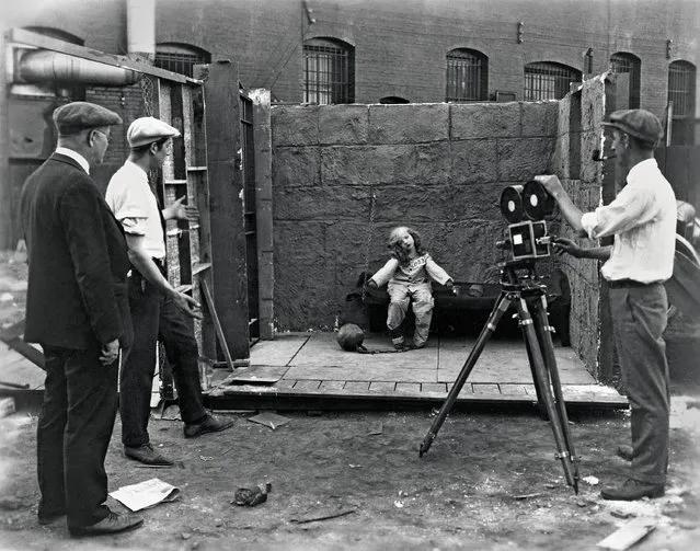 Child star Virginia Davis on an outdoor set for the finale of Alice’s Spooky Adventure (1924), one of Walt Disney’s early silent short films, which mixed live action with animation. Disney (second from left) directs. (Photo by Courtesy Walt Disney Archives Photo Library)