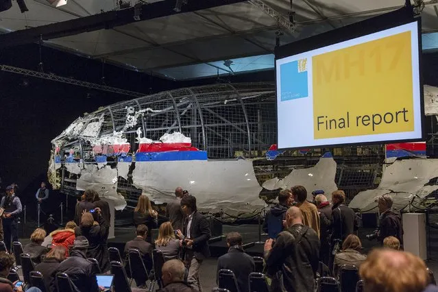 The reconstructed airplane serves as a backdrop during the presentation of the final report into the crash of July 2014 of Malaysia Airlines flight MH17 over Ukraine, in Gilze Rijen, the Netherlands, October 13, 2015. The Dutch Safety Board, issuing long-awaited findings on Tuesday of its investigation into the crash of a Malaysian passenger plane over eastern Ukraine, is expected to say it was downed by a Russian-made. (Photo by Michael Kooren/Reuters)