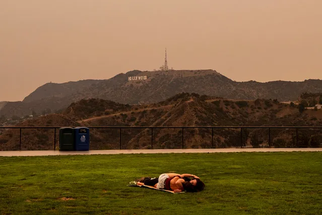 A couple kisses under an orange overcast sky in the afternoon in Los Angeles, California, USA, 10 September 2020. California wildfire smoke high in the atmosphere all over the state blocked the sunlight and turned the sky orange and yellow for most of the day. (Photo by Etienne Laurent/EPA/EFE)
