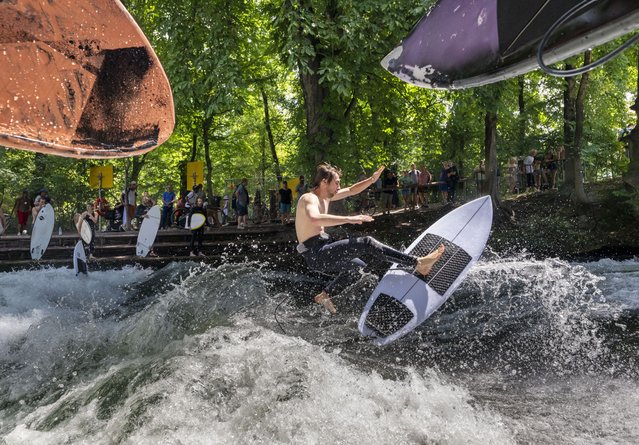 Antoine von Luchem jumps with his surfboard on the artificial Eisbach wave in the English Garden in Munich, on June 30, 2025. (Photo by Peter Kneffel/dpa via Reuters)