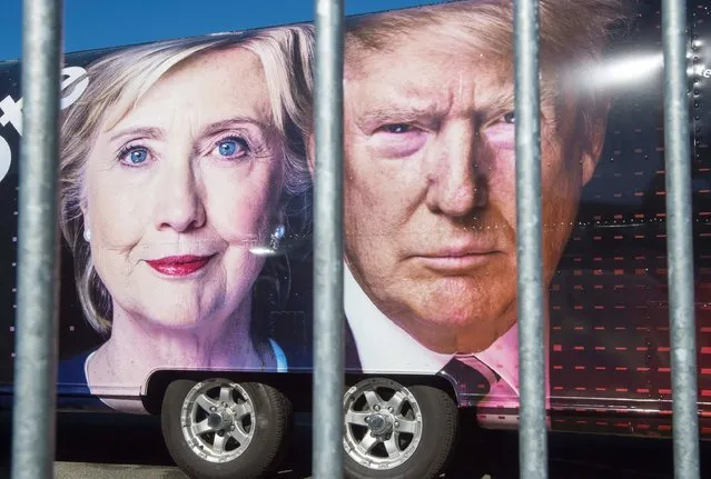Large images of Democratic nominee Hillary Clinton and Republican nominee Donald Trump are seen on a CNN vehicle, behind asecurity fence, on September 24, 2014, at Hofstra University, in Hempsted, New York. The university is the site of the first Presidential debate on September 26, between Democratic nominee Hillary Clinton and Republican nominee Donald Trump. (Photo by Paul J. Richards/AFP Photo)