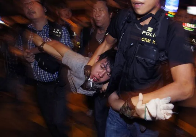 A protester is detained by police during a confrontation at Mong Kok shopping district in Hong Kong early November 26, 2014. Hong Kong riot police arrested 80 pro-democracy protesters on Tuesday in running clashes after several thousand demonstrators erected street barricades following clearance of part of a protest hotspot. (Photo by Liau Chung-ren/Reuters)