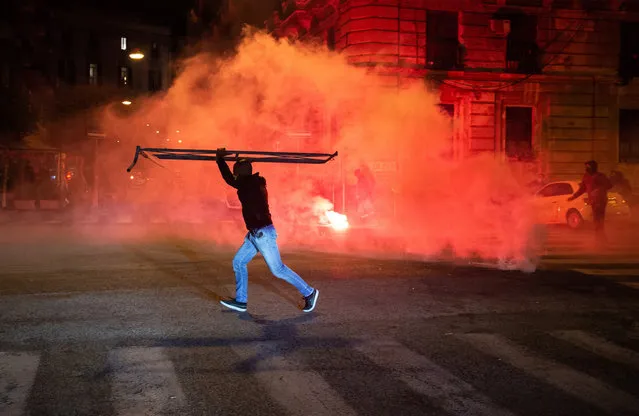 A man with a hurdle during the clashes to protest against the lockdown on October 23, 2020 in Naples, Italy. Protests and clashes with the police in Naples after the announcement by the Governor of the Campania Region Vincenzo De Luca of a possible regional lockdown to oppose the high number of infected in recent days. (Photo by Ivan Romano/Getty Images)