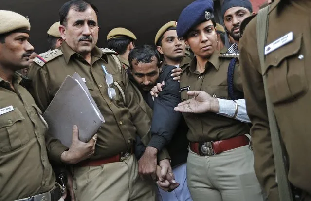 Policemen escort driver Shiv Kumar Yadav (C in black jacket) who is accused of a rape outside a court in New Delhi December 8, 2014. U.S. online ride-hailing service Uber has been banned from operating in the Indian capital after a female passenger accused one of its drivers of rape, a case that has reignited a debate about the safety of women in the South Asian nation. (Photo by Adnan Abidi/Reuters)