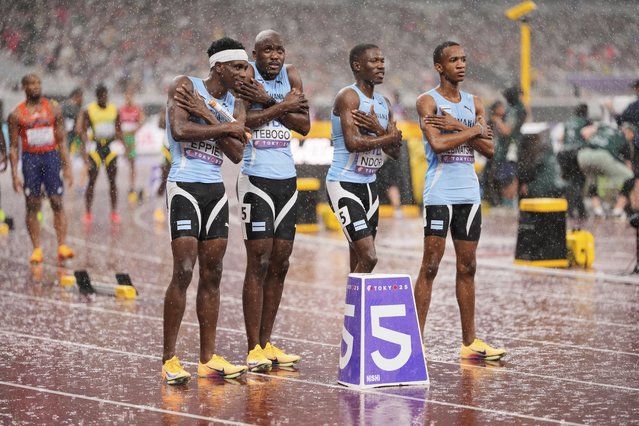 Team Botswana reacts to the cold rain before the start of the men's 4 X 400 meters relay at the World Athletics Championships in Tokyo, Sunday, September 21, 2025. (Photo by Eugene Hoshiko/AP Photo)