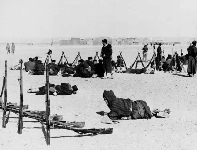 Moroccan volunteers rest with their weapons stacked nearby in Tagounit on the Algerian-Moroccan border, October 26, 1963.  Morocco announced that a four-power summit conference has been scheduled in Mali to settle the border conflict. (Photo by AP Photo)