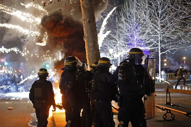 Fireworks explode as French riot police stand guard at Republique square during a demonstration against the government pension reform in Paris, France, 21 March 2023. Protests continued in France after the French prime minister announced on 16 March 2023 the use of Article 49 paragraph 3 (49.3) of the French Constitution to have the text on the controversial pension reform law be definitively adopted without a vote in the National Assembly (lower house of parliament). The bill would raise the retirement age in France from 62 to 64 by 2030. (Photo by Yoan Valat/EPA)