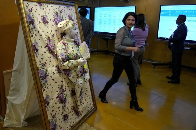 A visitor looks at a woman dressed up as part of an interactive art installation to spread awareness about communication organized by the Al Hadi Institute for Deaf, Blind and Learning Disabilities during the Arab Forum for Sustainable Development that was held at the United Nations headquarters in Beirut, Lebanon, Tuesday, March 14, 2023. (Photo by Bilal Hussein/AP Photo)