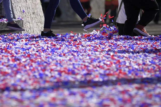A woman kicks confetti after ceremonies marking the 37th anniversary of the near-bloodless coup popularly known as “People Power” revolution that ousted the late Philippine dictator Ferdinand Marcos from 20-year-rule at the People's Power Monument in Quezon city, Philippines on Saturday February 25, 2023. (Photo by Aaron Favila/AP Photo)