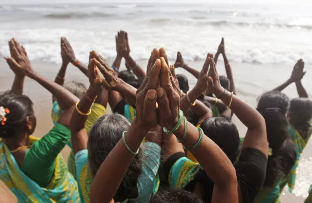 In this Friday, December 26, 2014 photo, Indian women offer prayers on the Marina Beach at the Bay of Bengal to commemorate the 10th anniversary of the 2004 Tsunami in Chennai, India. Crying onlookers took part in beachside memorials and religious services across Asia on Friday to mark the 10th anniversary of the Indian Ocean tsunami that left more than a quarter million people dead in one of modern history's worst natural disasters. (Photo by Arun Sankar K./AP Photo)