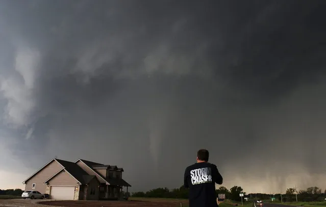 Storm chaser videographer and photographer Brad Mack records a tornado near a home in South Haven, in Kansas May 19, 2013. (Photo by Gene Blevins/Reuters)
