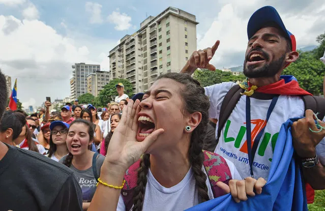 University students march against the government of Venezuelan President Nicolas Maduro in the streets of Caracas on October 26, 2016. Venezuela's political rivals are set to engage in a volatile test of strength on Wednesday, with the opposition vowing mass street protests as President Nicolas Maduro resists efforts to drive him from power. The socialist president and center-right-dominated opposition accuse each other of mounting a “coup” in a volatile country rich in oil but short of food. (Photo by Juan Barreto/AFP Photo)