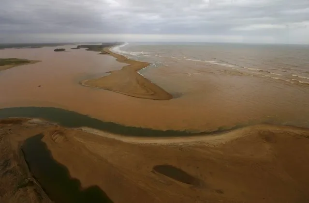 An aerial view of the mouth of Rio Doce (Doce River), which was flooded with mud after a dam owned by Vale SA and BHP Billiton Ltd burst, is seen as the river joins the sea on the coast of Espirito Santo, in Regencia Village, Brazil, November 21, 2015. (Photo by Ricardo Moraes/Reuters)