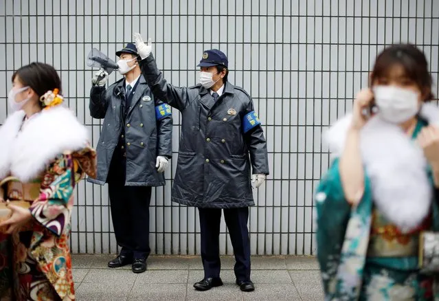 Police officers try to control youth wearing protective face masks at Coming of Age Day celebration ceremony at Yokohama Arena during the government declared the second state of emergency for the capital and some prefectures, amid the coronavirus disease (COVID-19) outbreak, in Yokohama, south of Tokyo, Japan on January 11, 2021. Of Tokyo's 23 wards, all but one have canceled or postponed the ceremonies, opting instead to offer mayors' congratulatory remarks online. The government last week declared a state of emergency for the capital and three surrounding prefectures. (Photo by Issei Kato/Reuters)