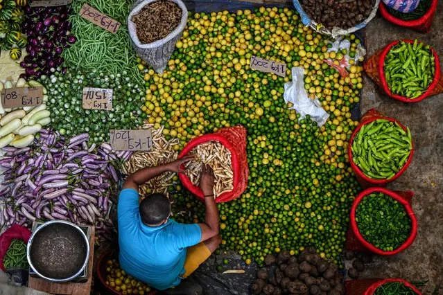 A vendor arranges vegetables as he waits for customers at a market in Colombo on March 21, 2023. Sri Lanka must not allow entrenched corruption to undermine a bailout for its bankrupt economy, the IMF said on March 21, 2023 after signing off on a $3 billion loan for the crisis-hit nation. (Photo by Ishara S. Kodikara/AFP Photo)
