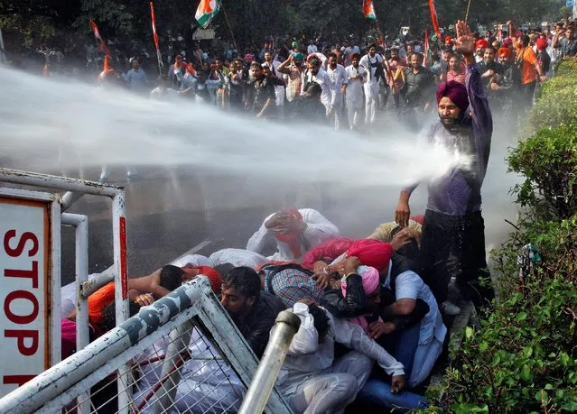 A demonstrator is hit by a water cannon used by police to disperse the protestors during a protest against what they say is state government’s failure to arrest those involved in the sacrilege of Guru Granth Sahib, the religious book of Sikhs, in Behbal Kalan village of Punjab in 2015, in Chandigarh, India October 26, 2016. (Photo by Ajay Verma/Reuters)