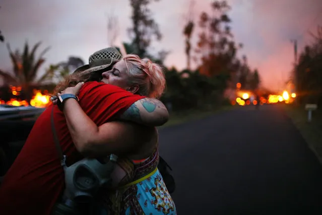 Zivile Roditis hugs Howie Rosin (L), shortly after Roditis' home was destroyed by lava from a Kilauea volcano fissure, in Leilani Estates, on Hawaii's Big Island, on May 25, 2018 in Pahoa, Hawaii. (Photo by Mario Tama/Getty Images)