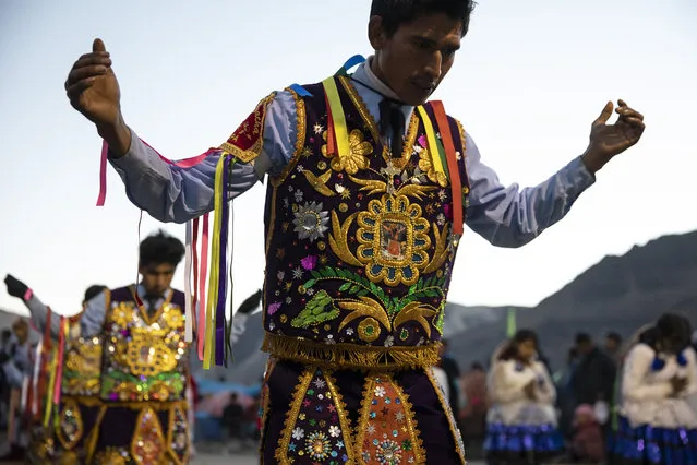 Costumed dancers pray on the first day of the annual Qoyllur Rit'i festival on May 27, 2018 in Ocongate, Peru. (Photo by Dan Kitwood/Getty Images)