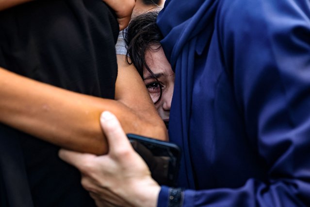 A young girl surrounded by women cries after identifying a member of her family among the dead at the al-Maamadani hospital, following an Israeli strike that killed more than 90 people on a school sheltering displaced Palestinians in Gaza City on August 10, 2024, amid the ongoing conflict between Israel and the Hamas movement. The Israeli military said it struck a Hamas “command and control centre” that was “embedded” in Al-Tabi'een school in the Daraj neighbourhood. (Photo by Omar Al-Qattaa/AFP Photo)
