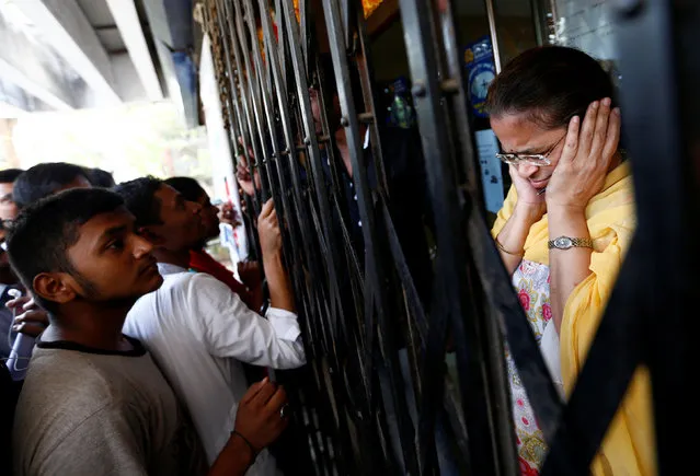 A bank employee reacts as people shout while they wait to enter a bank in Mumbai, India, November 10, 2016. (Photo by Danish Siddiqui/Reuters)