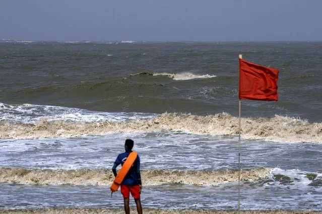 A lifeguard stands during high tide at a deserted Juhu beach on the Arabian Sea cost in Mumbai, India, Tuesday, June 13, 2023. (Photo by Rafiq Maqbool/AP Photo)