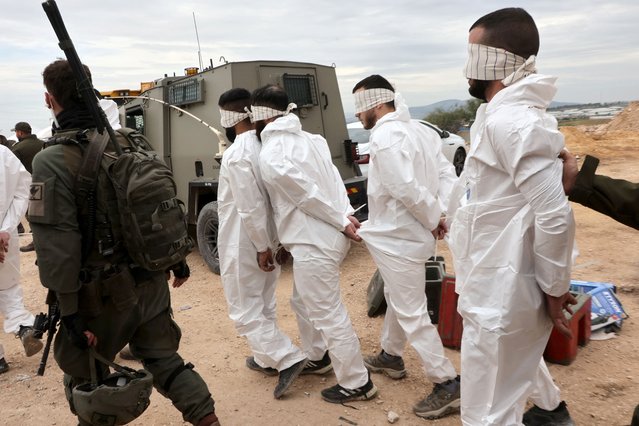 Israeli soldiers transfer Palestinian men arrested during a military raid on Jenin, near the Muqeibila crossing on the border with the occupied-West Bank, on January 22, 2025. Gunfire and explosions rocked the Jenin area of the occupied West Bank on January 22, an AFP journalist reported, as the Israeli military kept up a large-scale raid for a second day. (Photo by GIL Cohen-Magen/AFP Photo)