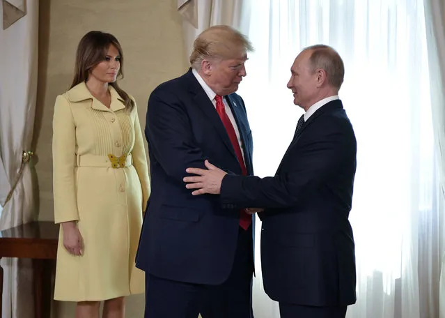 U.S. President Donald Trump shakes hands with Russia's President Vladimir Putin next to US First Lady Melania Trump (L) ahead a meeting in Helsinki, on July 16, 2018. (Photo by Alexei Nikolsky/Sputnik/Kremlin via Reuters)