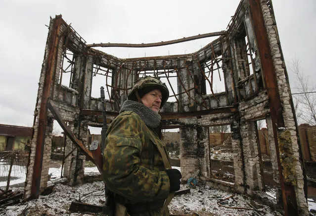A member of the armed forces of the separatist self-proclaimed Donetsk People's Republic looks on near a building destroyed during battles with the Ukrainian armed forces in Vuhlehirsk, Donetsk region, February 4, 2015. (Photo by Maxim Shemetov/Reuters)