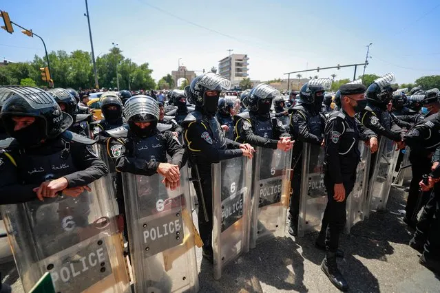 Iraqi security forces deploy near the gate of the green zone in Baghdad during a demonstration marking Labour Day on May 1, 2023, to demand a law establishing a salary grid to reduce pay inequalities for around 3 million government employees in the country. (Photo by Ahmad Al-Rubaye/AFP Photo)