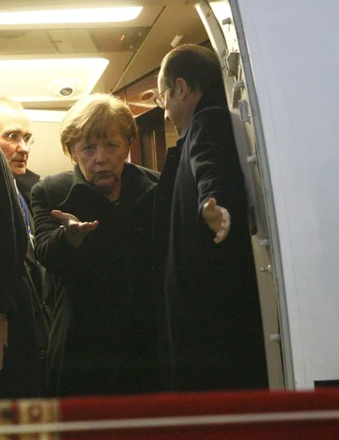 Germany's Chancellor Angela Merkel (L) and France's President Francois Hollande walk out after a meeting inside a plane at an airport near Minsk, February 11, 2015. (Photo by Valentyn Ogirenko/Reuters)