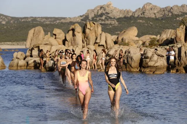 Lithuanian fashion model Edita Vilkeviciute (L) and French Model and Etam's muse Constance Jablonski (R) walk in the water to present Etam swimsuit collection at the Domaine de Murtoli in Sartene, on the French Mediterranean island of Corsica on May 12, 2022. (Photo by Pascal Pochard-Casabianca/AFP Photo)