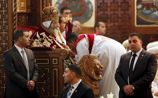 Pope Tawadros II (seated), the 118th Pope of the Coptic Orthodox Church of Alexandria and Patriarch of the See of St. Mark Cathedral, is surrounded by guards as he leads Egypt's Coptic Christmas eve mass, in Cairo, Egypt, January 6, 2016. (Photo by Amr Abdallah Dalsh/Reuters)