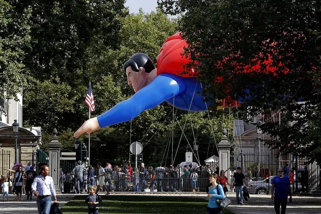 A giant inflatable Superman flies past the U.S. embassy during the Balloon Day Parade in Brussels, on September 7, 2013. Giant figures representing well-known comic strips and Belgian characters are parading as part of the “Comic Strip Festival”. (Photo by Yves Logghe/Associated Press)