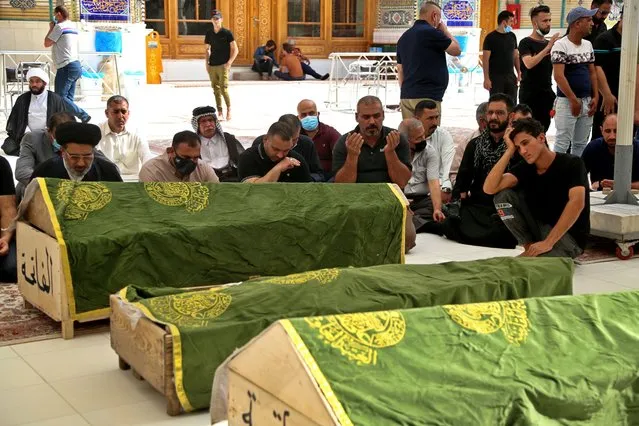 Mourners pray near the coffins of coronavirus patients who were killed in a hospital fire, during their funeral at the Imam Ali shrine in Najaf, Iraq, Sunday, April 25, 2021. Iraq’s Interior Ministry said Sunday that over 80 people died and over 100 were injured in a catastrophic fire that broke out in the intensive care unit of a Baghdad hospital tending to severe coronavirus patients in the early morning Sunday. (Photo by Anmar Khalil/AP Photo)