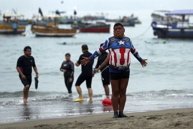 Open water swimmer Robert Yatto warms up in his Captain America swimsuit on Pescadores beach where swimming in the ocean is booming while pools are closed due to the COVID-19 pandemic in Lima, Peru, at sunrise Tuesday, April 27, 2021. Yatto, a former police officer who has been swimming in the Pacific for the past 30 years, said the sport is expensive, citing the $400 price tag of his suit. (Photo by Martin Mejia/AP Photo)