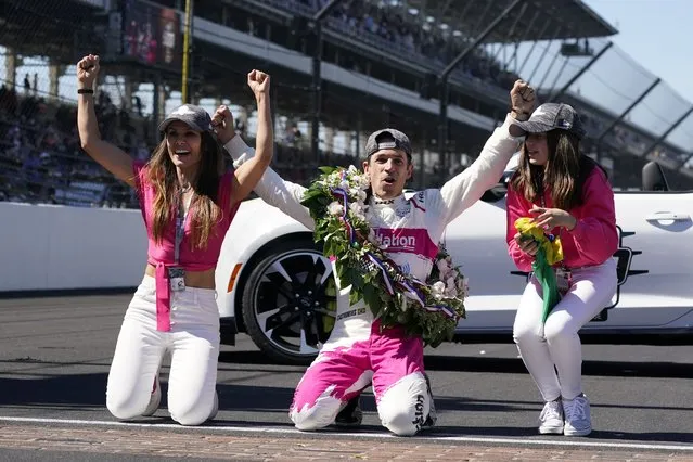 Helio Castroneves, of Brazil, celebrates winning the Indianapolis 500 auto race at Indianapolis Motor Speedway with Adriana Henao, left, and Mikaella Castroneves, Sunday, May 30, 2021, in Indianapolis. (Photo by Darron Cummings/AP Photo)